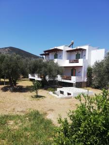 uma casa branca com árvores em frente em Madilides em Platis Gialos, Sifnos