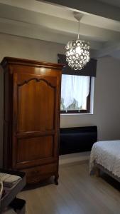 1 dormitorio con armario de madera y lámpara de araña en Chambres d'hôte de Sauviolle, en Frontenac 12 fotos más