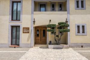 a building with a tree in front of a door at Hôtel l'Aragon in Carcassonne