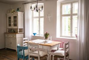 - une salle à manger avec une table, des chaises et des fenêtres dans l'établissement Malom Udvar Vendégház, à Óbánya