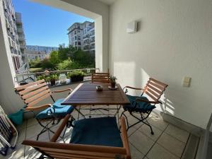 a patio with a wooden table and chairs on a balcony at Refugium am Engelbecken in Berlin