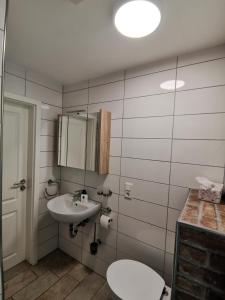 uma casa de banho com um lavatório, um WC e um espelho. em Bleckmanns Hof em Werne an der Lippe