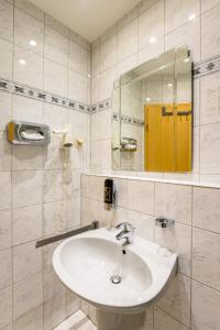ein weißes Badezimmer mit einem Waschbecken und einem Spiegel in der Unterkunft Hotel Glockengasse in Köln