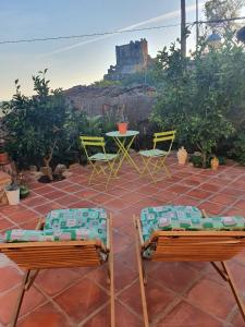 um pátio com cadeiras e uma mesa com um castelo ao fundo em El Balcon de Los Sueños em Trevejo