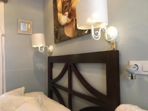 a bedroom with a bed with two lamps and a painting at Apartamento con encanto Manchigon in Palomares del Río