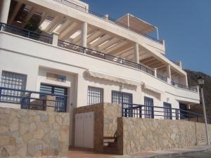 a white house with a balcony on top of it at Apartamentos Sotavento Carboneras in Carboneras