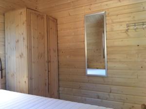 a bedroom with a wooden wall with a window at Blockhaus Harzblick4C in Braunlage