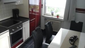 une cuisine avec une table et des chaises ainsi qu'une cuisine avec une cuisinière et une fenêtre dans l'établissement Ferienbauernhof, à Lügde