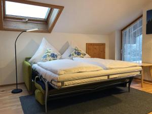 ein großes Bett in einem Zimmer mit einer Lampe in der Unterkunft Gästehaus Math in Oberstdorf