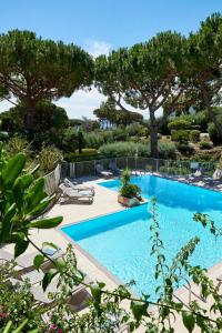 een zwembad met ligstoelen en bomen bij Domaine Du Calidianus in Sainte-Maxime