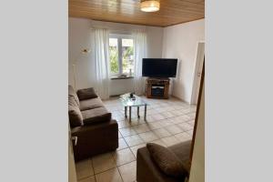 sala de estar con sofá y TV en Ferienwohnung Lutz, en Ascheberg