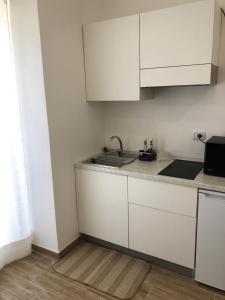 a kitchen with white cabinets and a sink at Karol in Pozzallo
