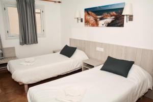 een kamer met 2 bedden en een schilderij aan de muur bij Rosamar Holidays Apartments in Cala Ratjada