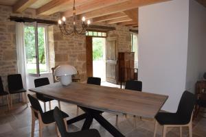 comedor con mesa de madera y sillas en Domaine du BOURNAT, en Camboulit