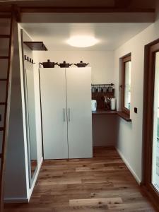 cocina con armarios blancos y suelo de madera en Village Apartments, en Šentilj