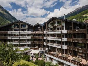 una imagen de un hotel con montañas en el fondo en Hotel National Zermatt, en Zermatt