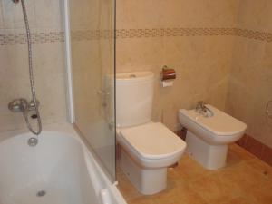 a bathroom with a toilet and a shower and a sink at Apartamentos Sotavento Carboneras in Carboneras