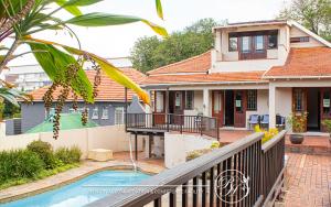 a house with a balcony and a swimming pool at Roseland House in Durban