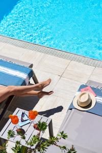 a person sitting on a bed next to a swimming pool at Domaine Du Calidianus in Sainte-Maxime