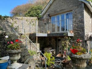 an old stone house with stairs and a balcony at The Stables, Ulverston in Ulverston