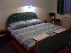 a bedroom with a bed with a blue comforter at Rooms Cipot in Murska Sobota