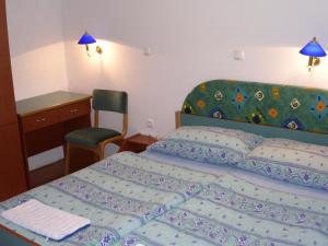 Schlafzimmer mit einem Bett, einem Schreibtisch und einem Stuhl in der Unterkunft Rooms Cipot in Murska Sobota