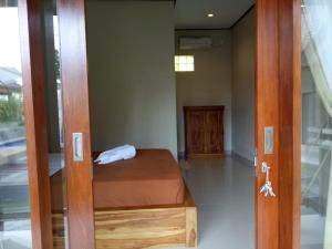 a small bedroom with a bed in a room at Lilis Cempaka Mas Guesthouse in Canggu
