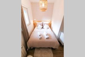 a bedroom with a bed with two slippers on it at LE COCOON / PROCHE GARE / NETFLIX in Sens