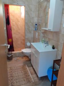 ein Badezimmer mit einem weißen Waschbecken und einem WC in der Unterkunft IVA apartments in Šilo