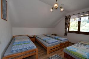 een kamer met 3 bedden en een raam bij Apartmany Kenka in Spišská Stará Ves