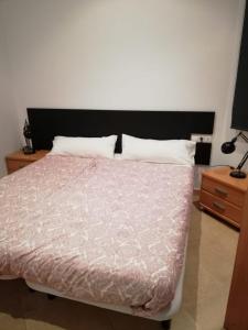 a bedroom with a bed with a pink comforter at Apartment Sabadell 2 in Sabadell