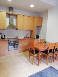 a kitchen with a wooden table and wooden cabinets at Apartment Sabadell 2 in Sabadell