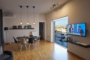 Televízia a/alebo spoločenská miestnosť v ubytovaní Acropolis View Penthouse N
