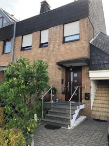 una casa de ladrillo con escaleras que conducen a la puerta principal en Ferienwohnung Bergisch Gladbach, en Bergisch Gladbach