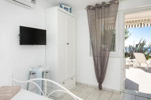 a bedroom with a bed and a tv on a wall at Apartment Alida in Krk