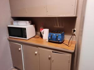 a kitchen counter with a microwave and a toaster at Central Holiday Home in Tauranga