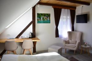 een slaapkamer met een bed, een bureau en stoelen bij House Boro in Jezerce