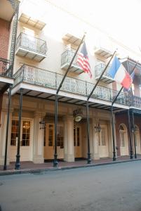 a building with two flags on a street at Hotel St. Marie in New Orleans