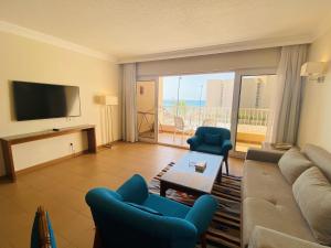 a living room with a couch and chairs and a television at Hurghada Suites & Apartments Serviced by Marriott in Hurghada