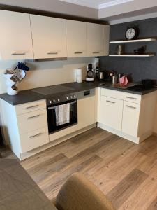 a kitchen with white cabinets and an oven at African Suite - Maintal bei Frankfurt in Maintal