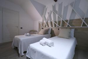 - 2 lits avec serviettes dans une chambre dans l'établissement Affittacamere I Due Leoni, à Turin
