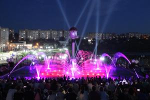 a crowd of people standing in front of a fountain at night at Нові Апартаменти біля Софіївського Парка in Umanʼ