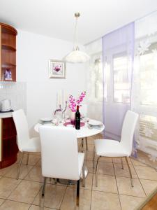a dining room with a white table and white chairs at Center Apartment Silvana in Split
