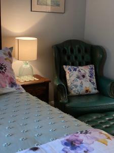 
a bed room with a chair and a lamp at Palmyra B&B in Rainbow Flat
