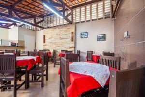 une salle à manger avec des tables, des chaises et des couvertures rouges dans l'établissement Luxury Flats Ambiente Cristão, à Fortaleza