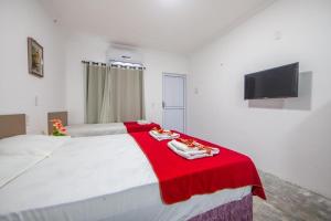 a large white bed with a red blanket on it at Luxury Flats Ambiente Cristão in Fortaleza