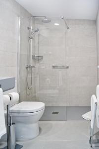 a bathroom with a toilet and a glass shower at Sanom Beach Resort Only Adults in Playa del Ingles