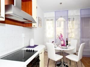 スプリトにあるセンター アパートメント シルヴァーナの白いキッチン(テーブル、白い椅子付)