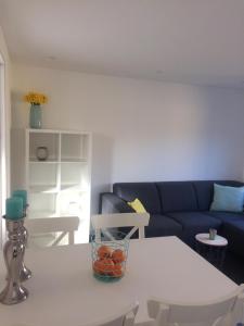 ein Wohnzimmer mit einem weißen Tisch und einem blauen Sofa in der Unterkunft Zomerhuis Zuid 1 in Egmond aan Zee