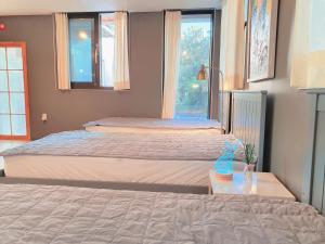 a bedroom with two beds and a window at Picasso Guesthouse in Mokpo